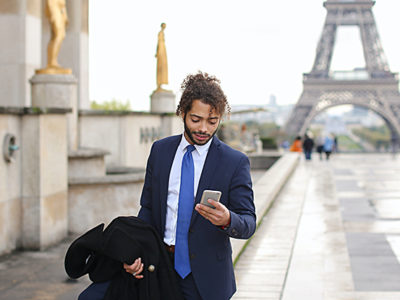 Businessman with smartphone near Eiffel Tower